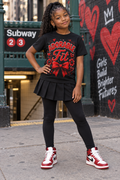 Black youth model wearing Adorable Fit red bow and flowers black graphic tee